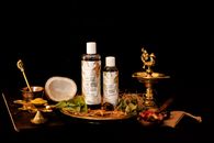 An elegant still life featuring Ayurvedic haircare oils with traditional Indian decor on a black background.